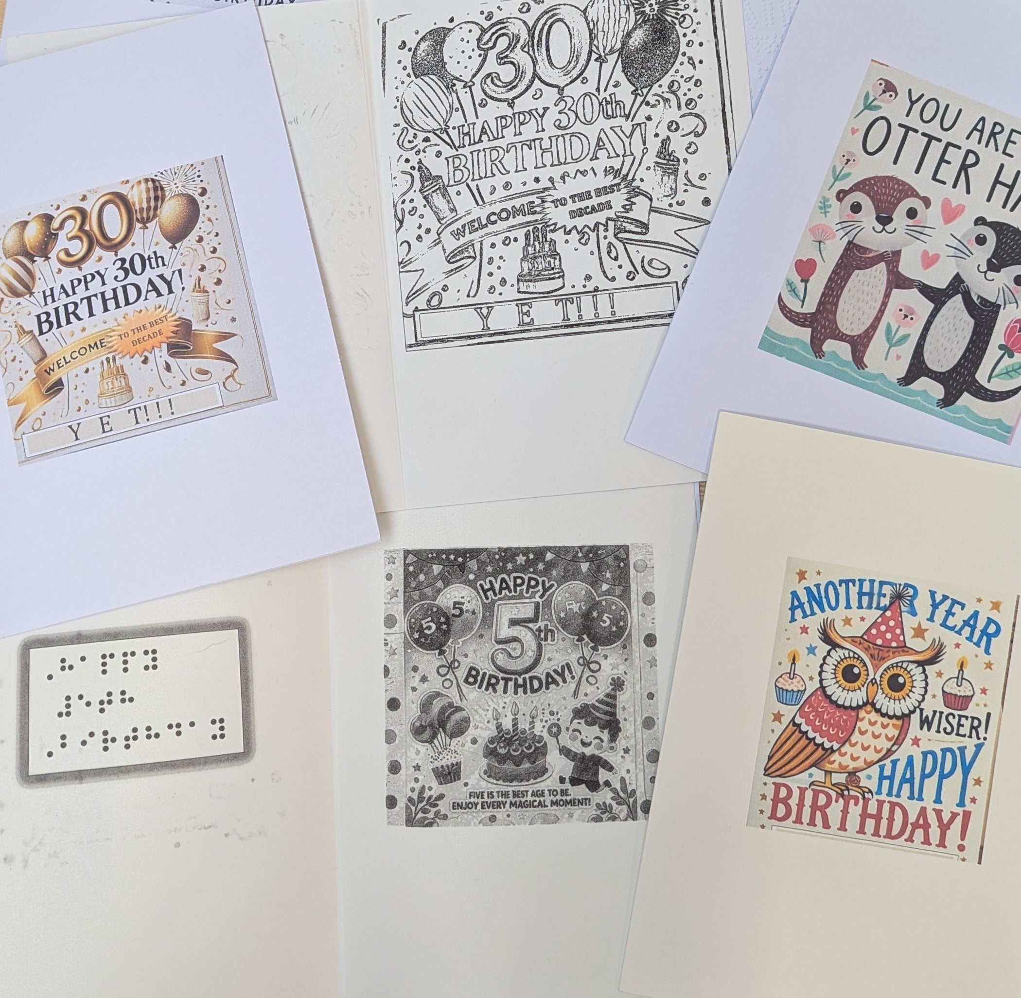 Collection of braille birthday cards with various designs on a white background